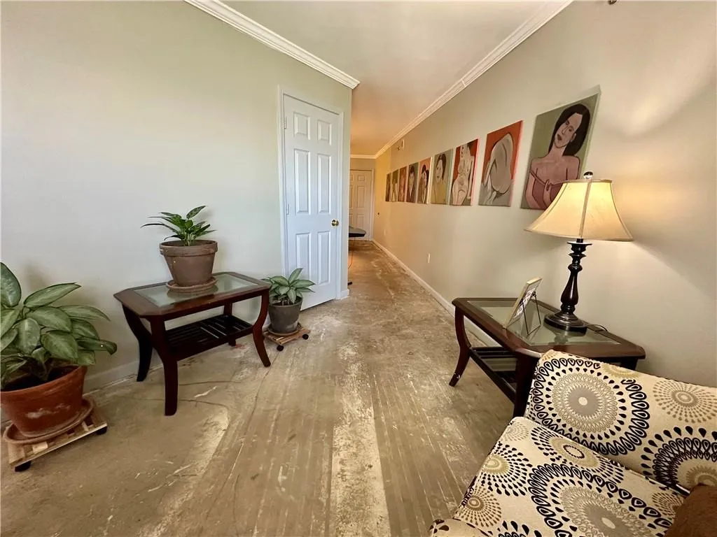 Corridor featuring wood-type flooring and crown molding