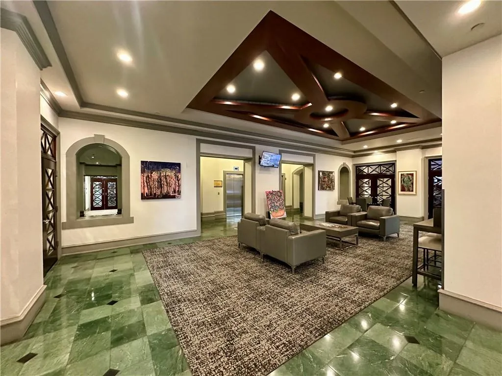Community lobby with recessed lighting, ornamental molding, and a raised ceiling