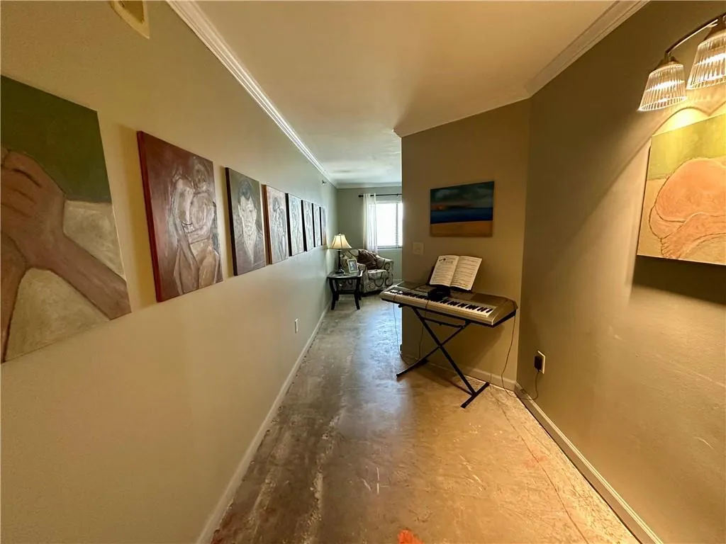 Corridor with crown molding and concrete flooring