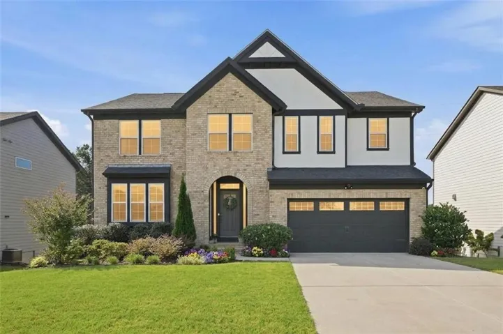 Two-story residence featuring a brick and siding facade with dark trim