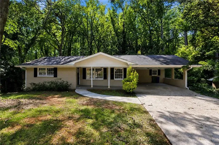 Ranch-style residence featuring a covered front porch, carport, and a paved driveway