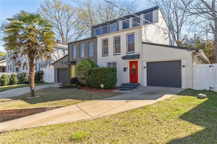 View of front of property featuring a garage and a front yard