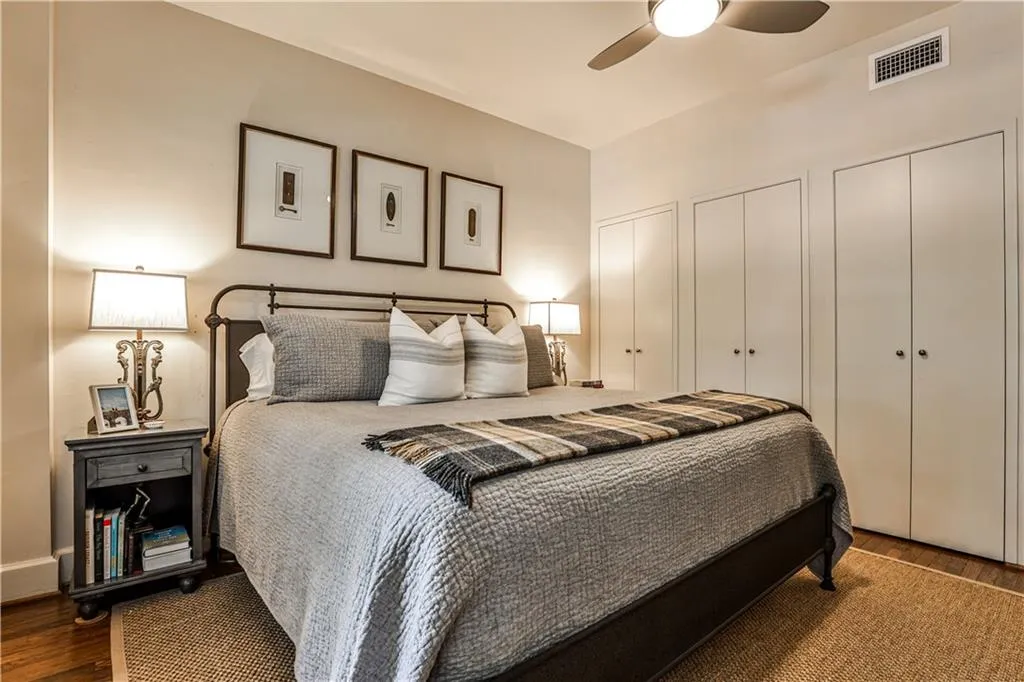 Bedroom featuring wood finished floors, two closets, and a ceiling fan