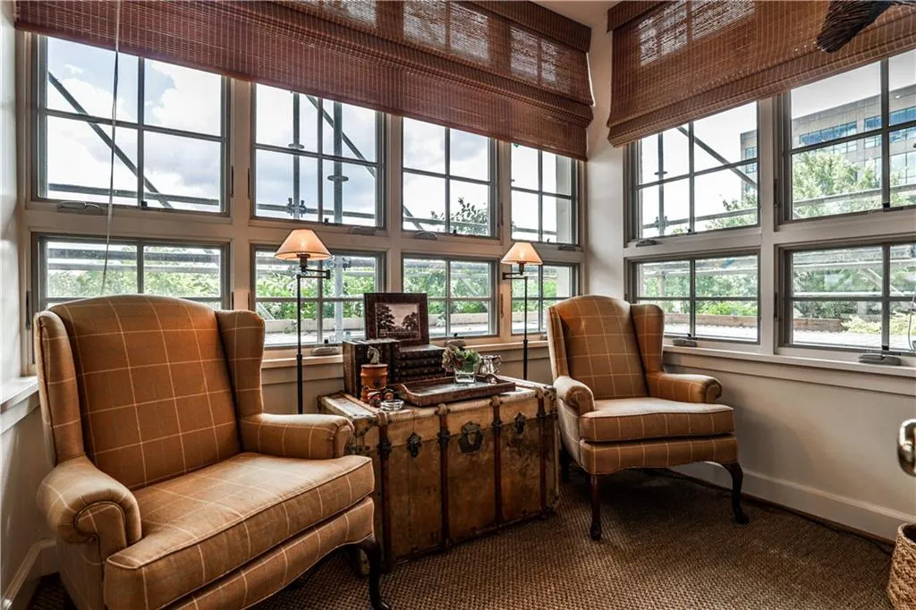 Sitting room featuring a towering ceiling and baseboards