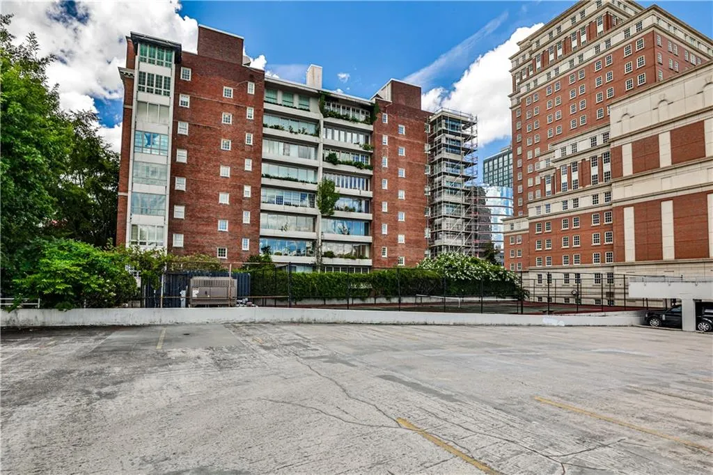 View of apartment building / complex featuring uncovered parking