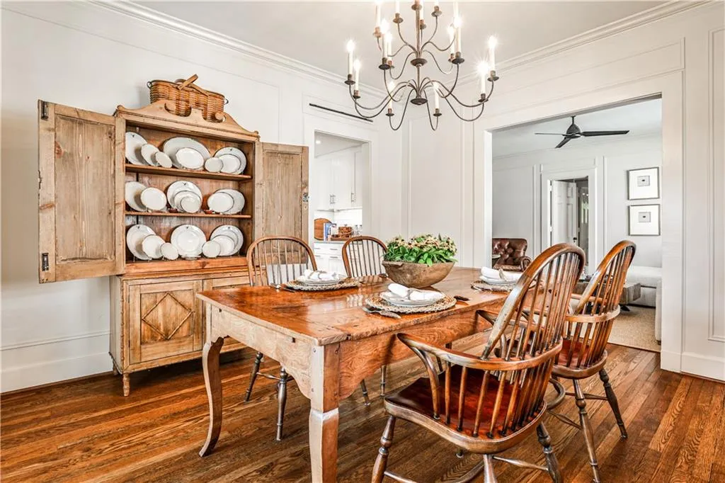 Dining space featuring a chandelier, dark wood finished floors, ceiling fan, and crown molding