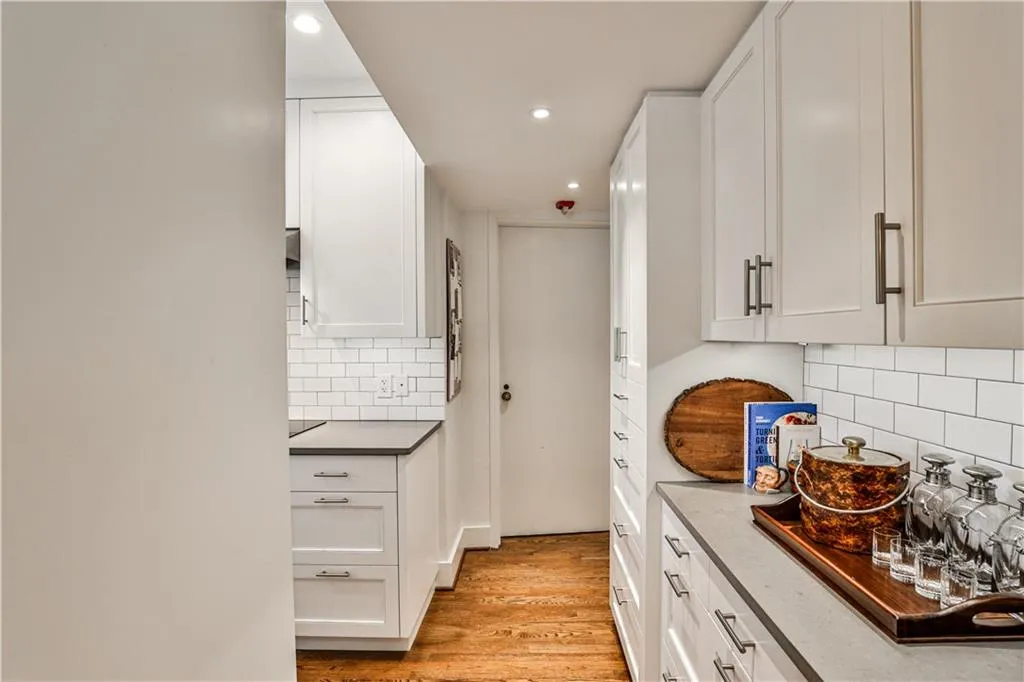 Kitchen featuring light wood-style floors, recessed lighting, white cabinets, and decorative backsplash