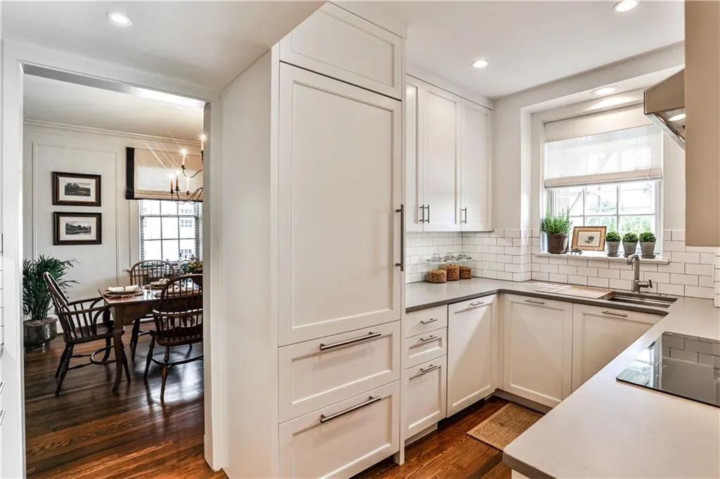 Kitchen featuring dark wood-style flooring, white cabinets, tasteful backsplash, black electric cooktop, and recessed lighting