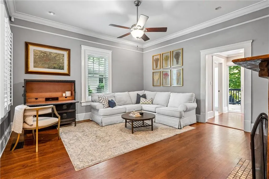 Living area featuring crown molding, a ceiling fan, and dark wood-type flooring