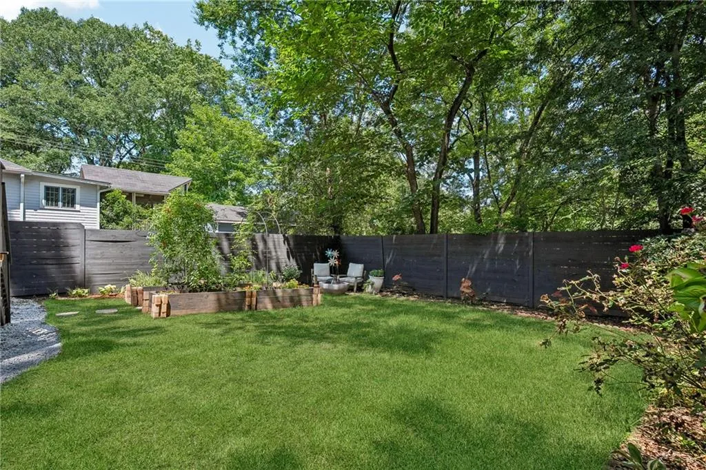 Fenced backyard featuring view of scattered trees