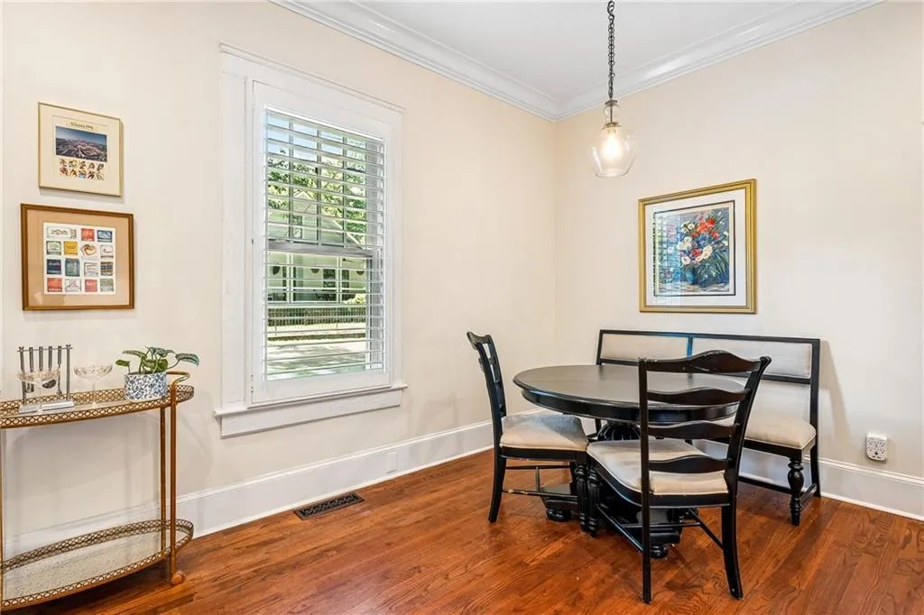 Dining area with ornamental molding and dark wood finished floors