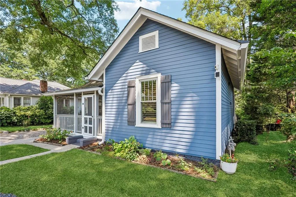 Bungalow-style home featuring a sunroom and a front lawn