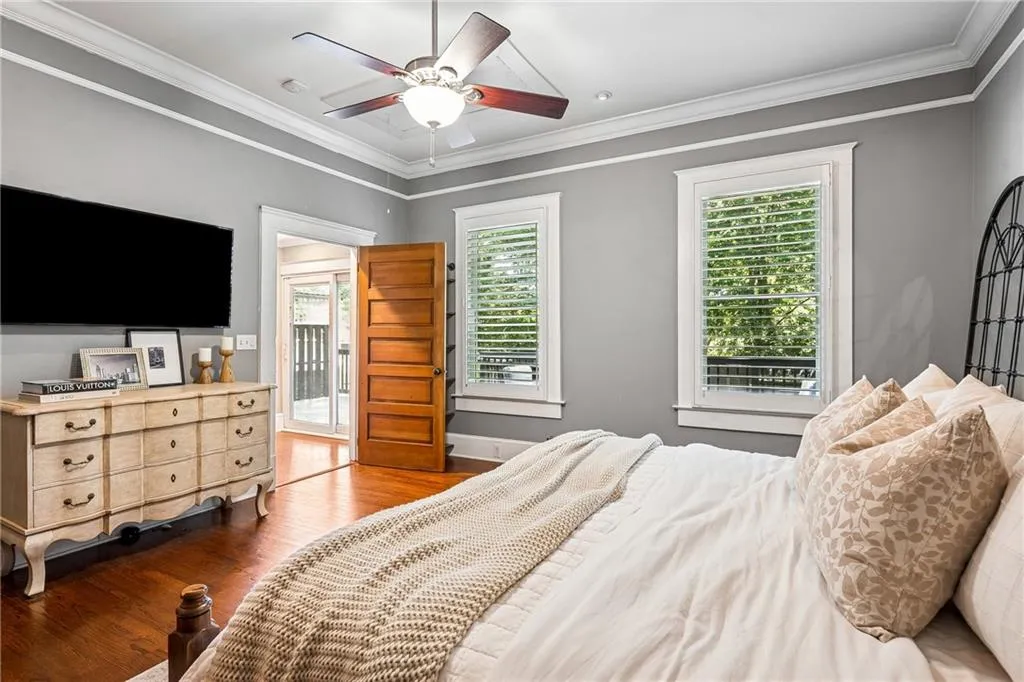 Bedroom featuring crown molding, wood finished floors, and a ceiling fan