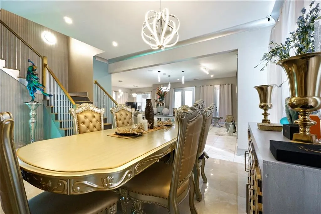 Open-concept dining area with a contemporary chandelier, recessed lighting, and tile flooring