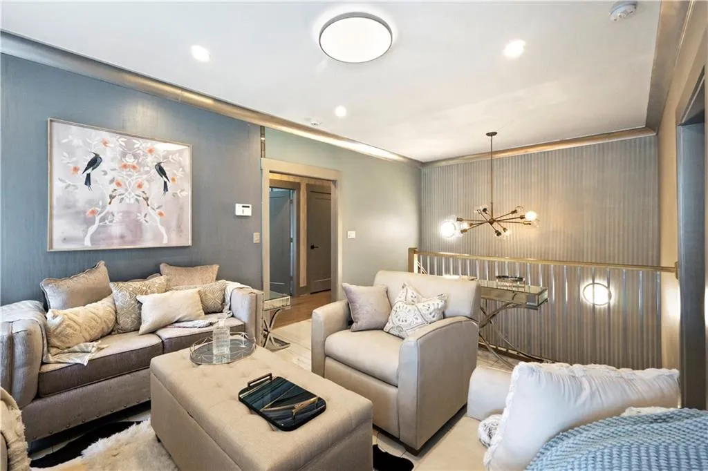 Recessed lighting, contemporary flush-mount ceiling light, decorative wall paneling, and an exposed bulb chandelier