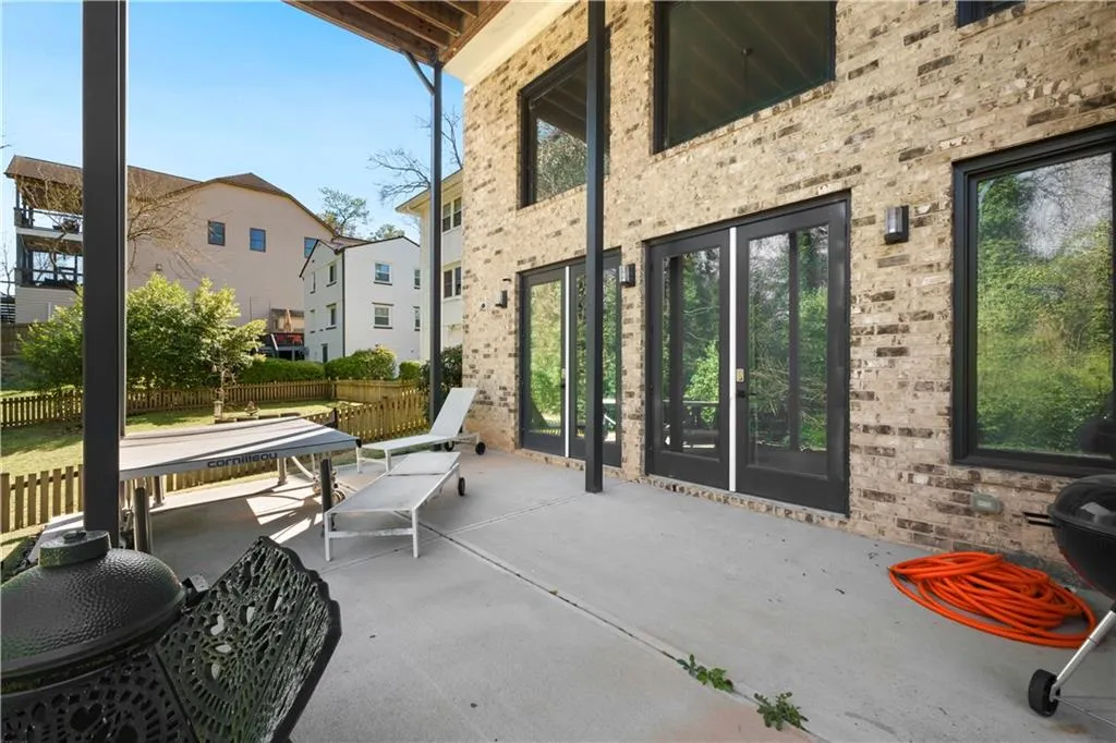 Expansive concrete patio with brick exterior and multiple glass-paned doors