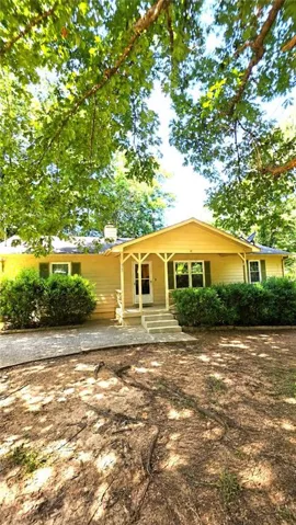 Single-story residence with a covered front porch, concrete steps, and a paved driveway