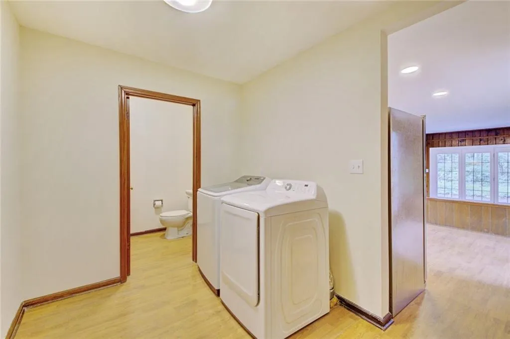 Clothes washing area featuring light hardwood / wood-style flooring and washing machine and clothes dryer