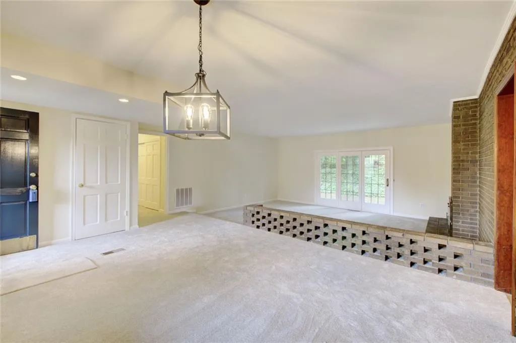 Carpeted living room featuring a notable chandelier