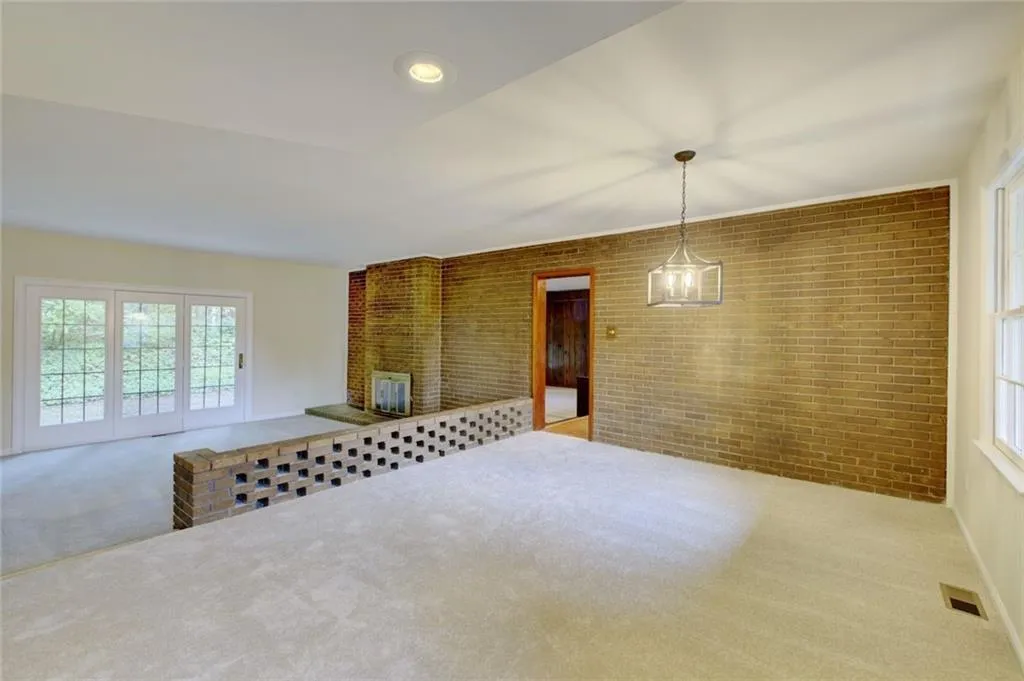 Carpeted empty room with brick wall