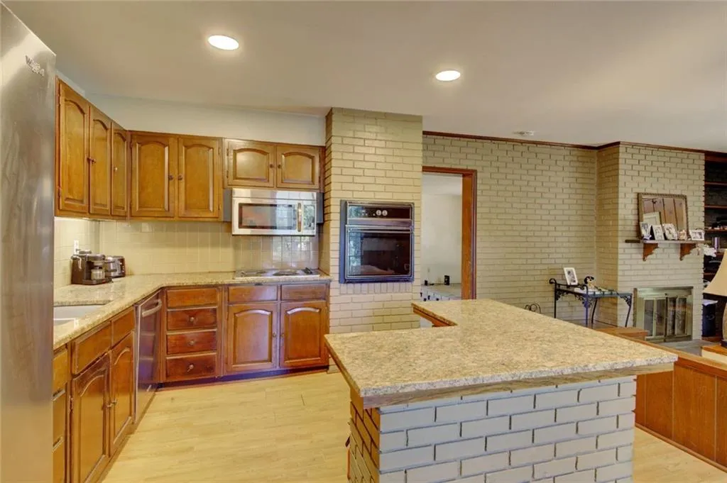 Kitchen featuring a center island, light hardwood / wood-style floors, appliances with stainless steel finishes, decorative backsplash, and sink
