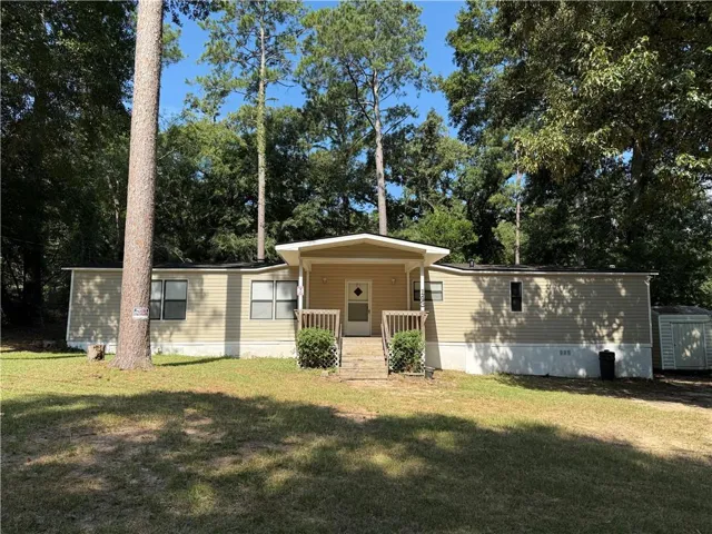 Single-story residence featuring light-colored siding, a covered front porch, and a gravel pathway