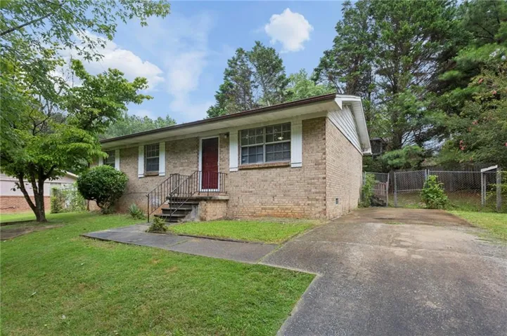 Brick exterior with white shutters and a red entry door