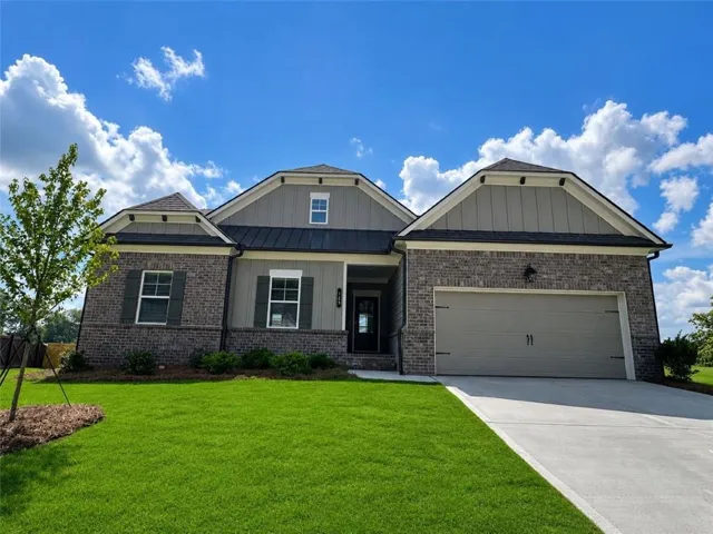 Single-story residence featuring a brick and siding exterior, a two-car garage, and a concrete driveway