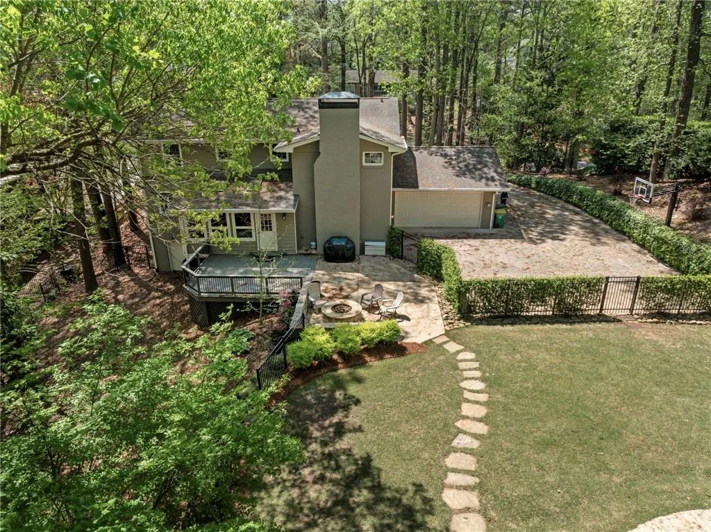 View of yard featuring a fire pit, fence, and a deck