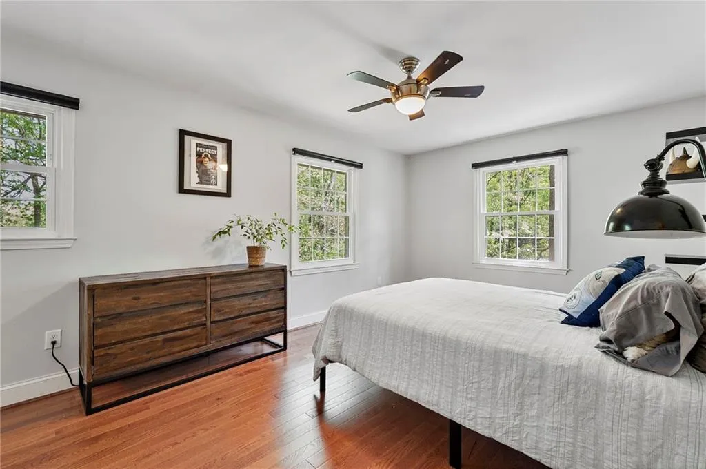 Bedroom featuring wood finished floors, baseboards, and multiple windows