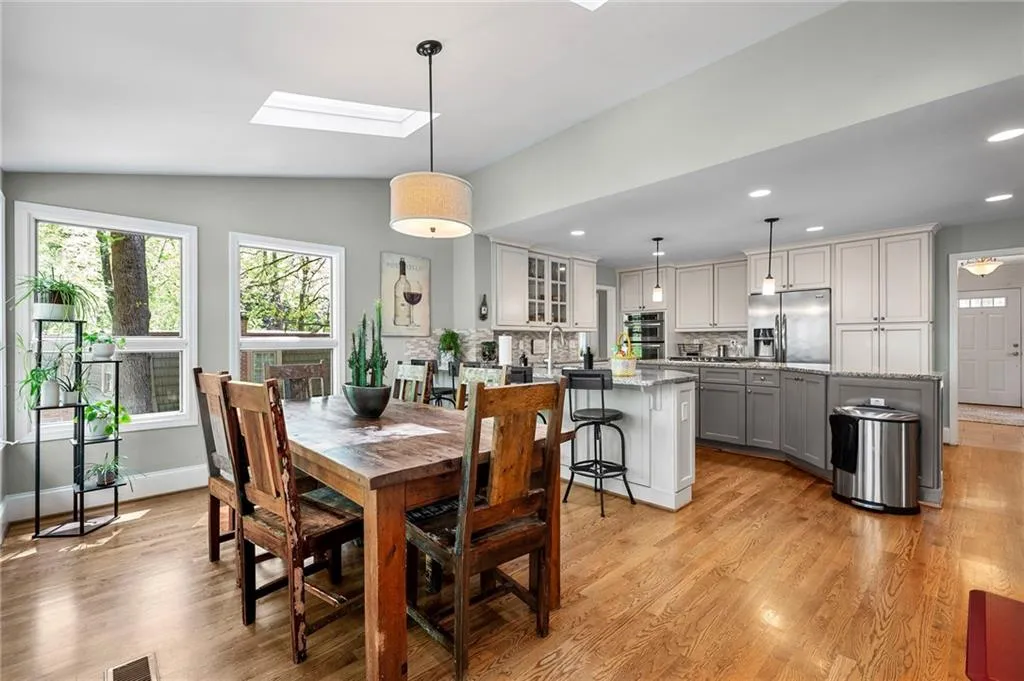 Dining space featuring light wood-style flooring, recessed lighting, baseboards, and lofted ceiling with skylight
