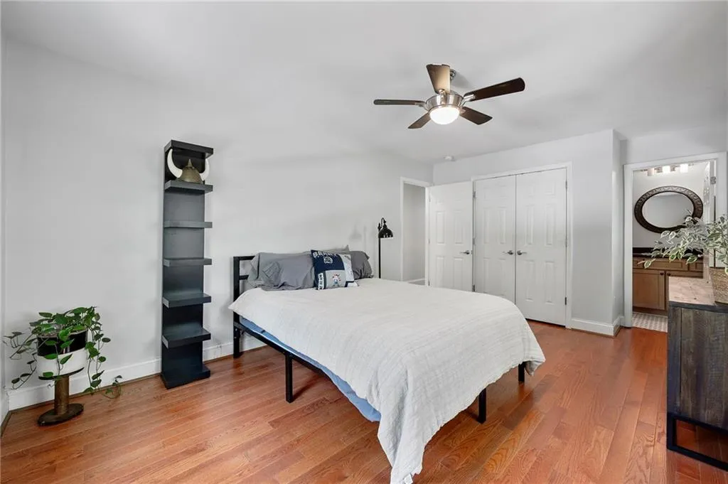 Bedroom featuring wood finished floors, ceiling fan, baseboards, and a closet