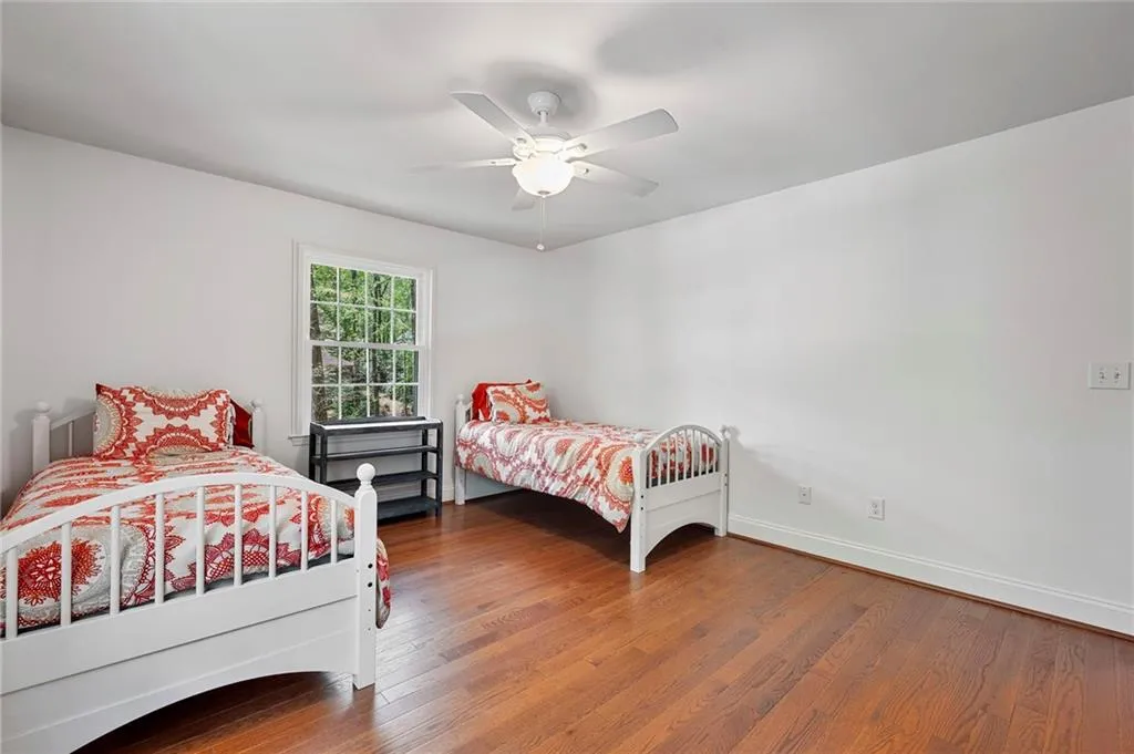 Bedroom featuring wood finished floors, ceiling fan, and baseboards