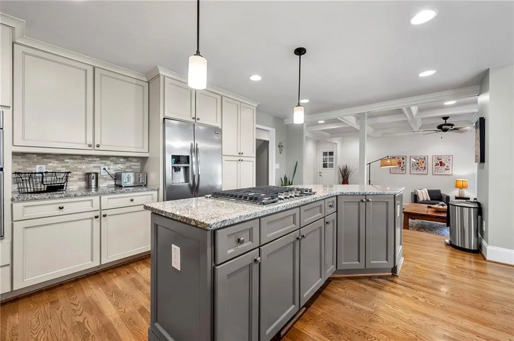 Kitchen featuring recessed lighting, stainless steel appliances, coffered ceiling, light wood finished floors, and gray cabinetry