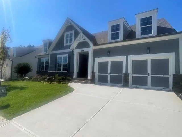 Contemporary exterior with dormer windows, a two-car garage, and a concrete driveway