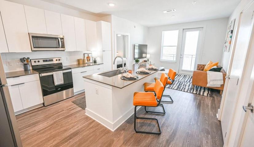 Kitchen featuring white cabinets, stainless steel appliances, sink, and light wood-type flooring