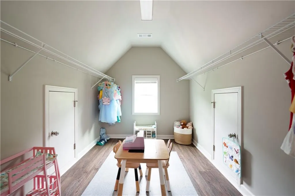 Spacious closet with vaulted ceiling and wood finished floors