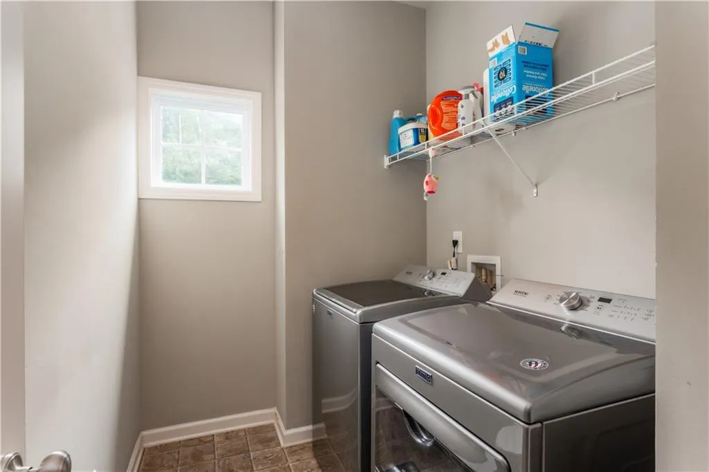 Washroom featuring washer and dryer and baseboards
