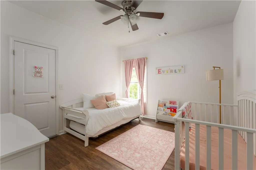 Bedroom with dark wood finished floors and a ceiling fan