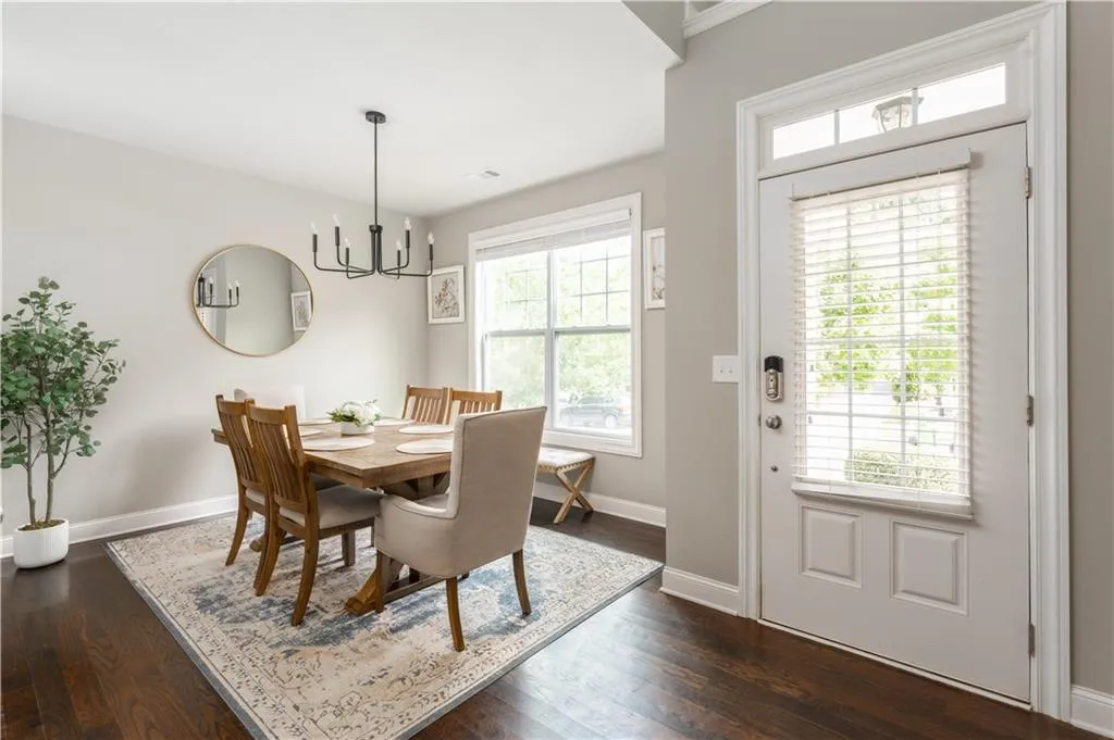 Dining area featuring plenty of natural light, dark wood finished floors, and a chandelier