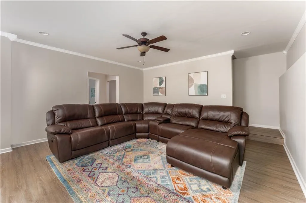 Living area featuring crown molding, a ceiling fan, wood finished floors, and recessed lighting