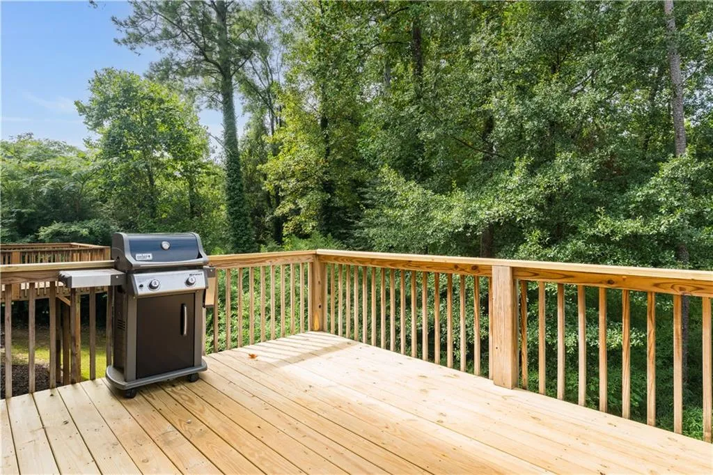 Wooden deck featuring area for grilling