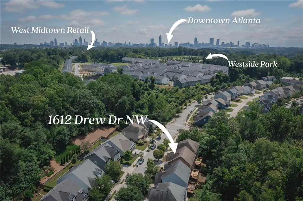 Aerial view of property and surrounding area featuring skyline and nearby suburban area