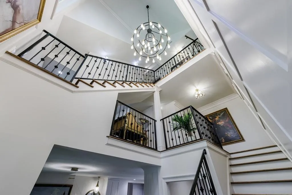 View of 3 story foyer with detailed wrought iron railing