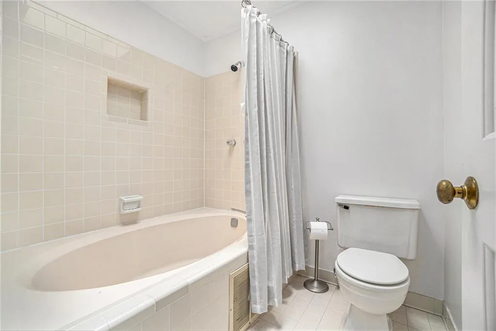 Bathroom with tile patterned flooring, tiled shower / bath combo, and crown molding Bathroom with tile patterned flooring, tiled shower / bath combo, and crown molding