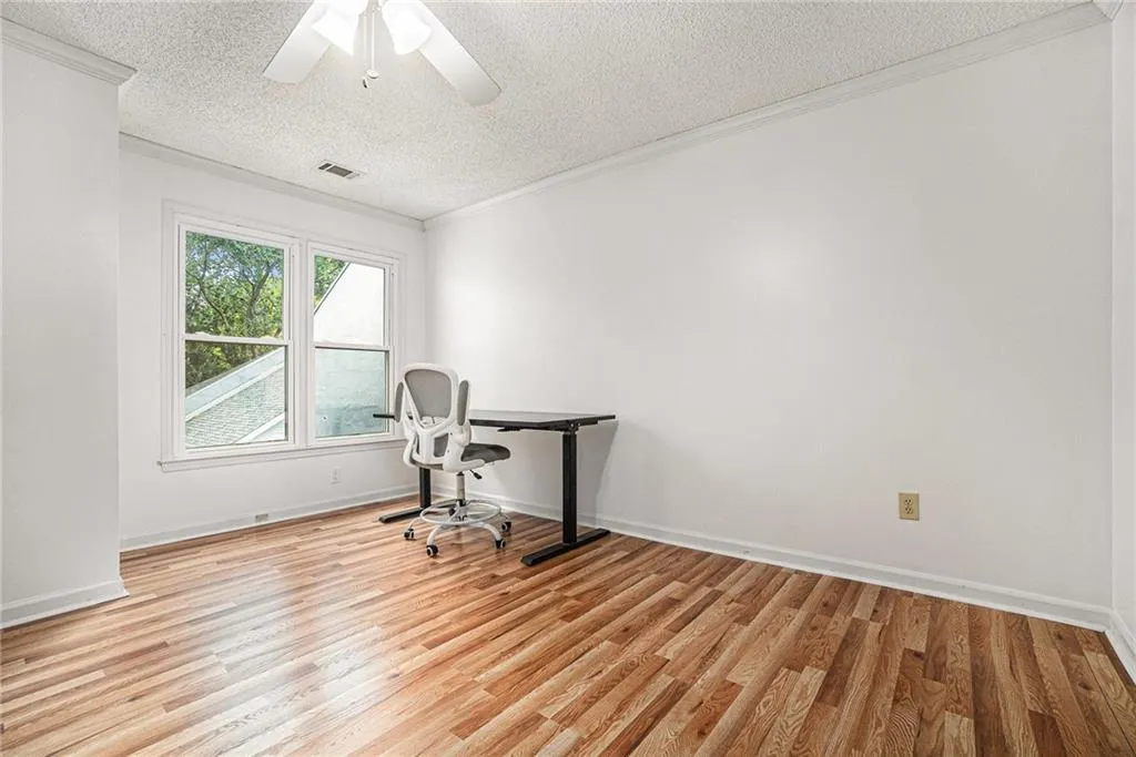 Office with crown molding, light wood-style floors, a textured ceiling, and ceiling fan Office with crown molding, light wood-style floors, a textured ceiling, and ceiling fan
