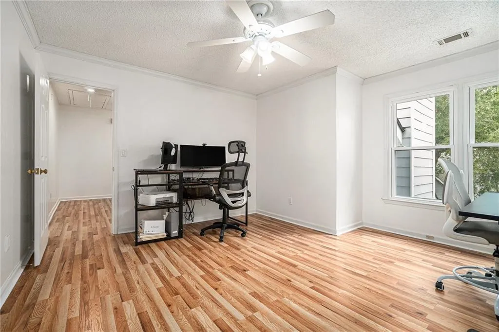 Office with light wood-style floors, a textured ceiling, crown molding, attic access, and a ceiling fan Office with light wood-style floors, a textured ceiling, crown molding, attic access, and a ceiling fan