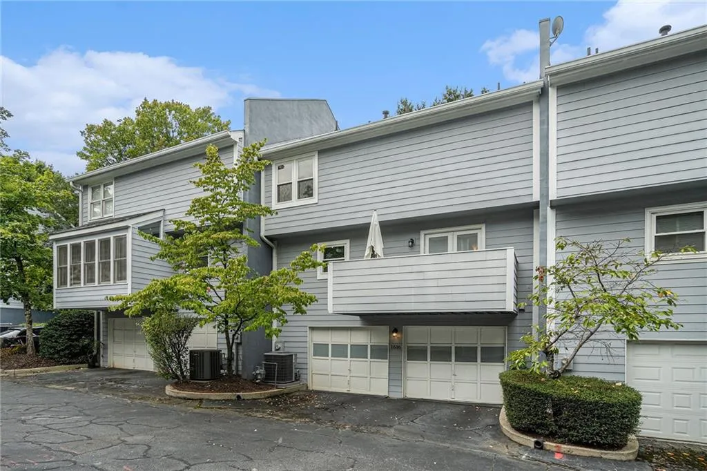 Rear view of house featuring an attached garage and a chimney Rear view of house featuring an attached garage and a chimney