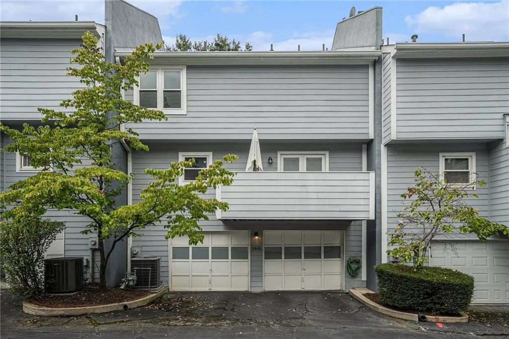 View of home's exterior with a chimney, a garage, and driveway View of home's exterior with a chimney, a garage, and driveway