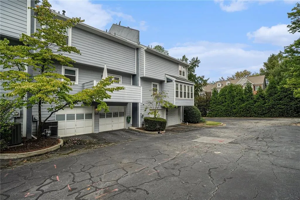 Back of house featuring asphalt driveway, a garage, and a residential view Back of house featuring asphalt driveway, a garage, and a residential view